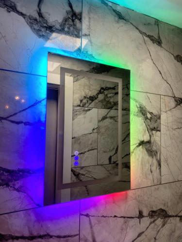a bathroom with a stone wall with a rainbow light at Kaoglen - Bali Pod - Hot Tub -Cairngorms - Pitlochry in Kirkmichael