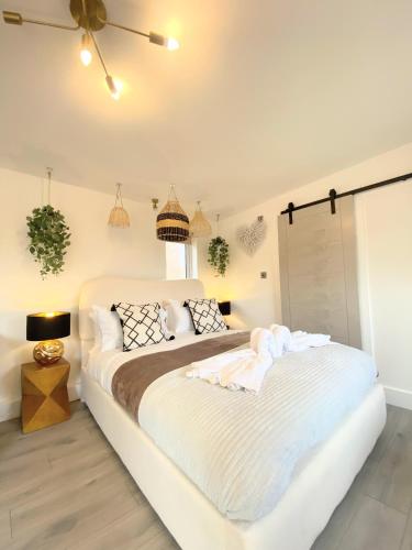 a white bedroom with a bed and a window at Kaoglen - Bali Pod - Hot Tub -Cairngorms - Pitlochry in Kirkmichael