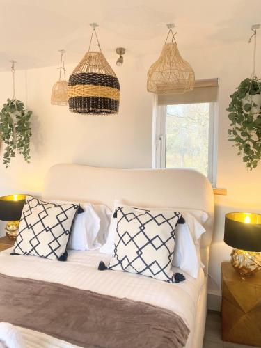 a bedroom with a bed with pillows and two lamps at Kaoglen - Bali Pod - Hot Tub -Cairngorms - Pitlochry in Kirkmichael