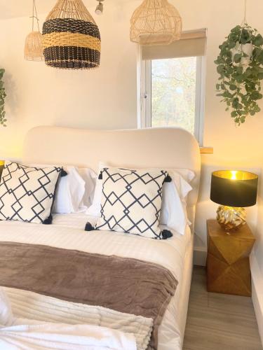 a bedroom with a bed with pillows and a window at Kaoglen - Bali Pod - Hot Tub -Cairngorms - Pitlochry in Kirkmichael
