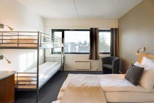 a dorm room with a bunk bed and a desk at St Svithun Hotel in Stavanger