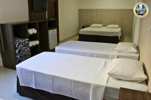 a room with two beds and a tv in it at Hotel Holiday Foz in Foz do Iguaçu