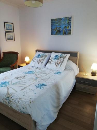 une chambre avec un lit avec une couette blanche dans l'établissement La Marine, à Cancale