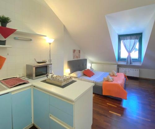 a bedroom with a bed and a kitchen with a counter at Casa Mirtillo in Turin