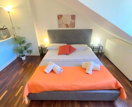 a bedroom with a large bed with an orange blanket at Casa Mirtillo in Turin