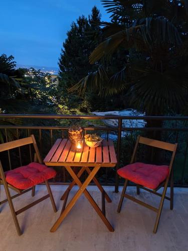 a wooden table and two chairs on a balcony at Palme Apartments in Opatija
