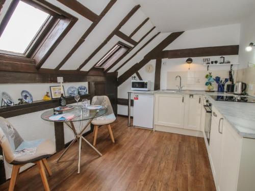 a kitchen with a table and chairs in a room at The Millers Roost at Dudgeley Mill in Church Stretton