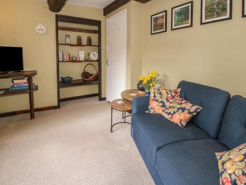 a living room with a blue couch and a table at The Millers Roost at Dudgeley Mill in Church Stretton