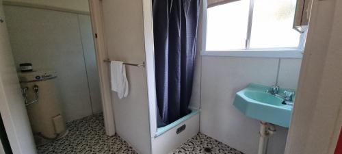 bagno con lavandino blu e finestra di Park Beach Holiday Cabins a Coffs Harbour