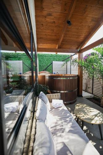 a porch with a bed and a wooden ceiling at Dasi סוויטות אירוח in Moshav Ramot