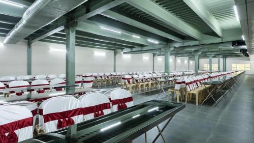 an empty room with rows of chairs and tables at Premier Greens in Mūlki
