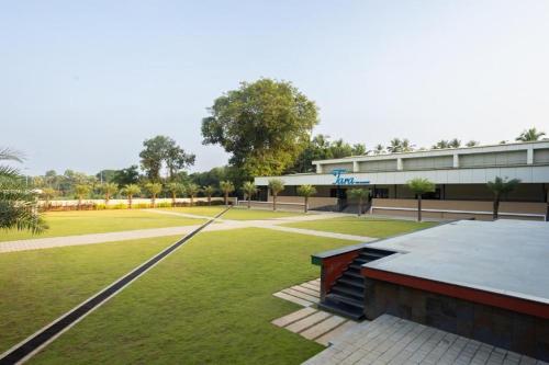 a building with a grassy field in front of it at Premier Greens in Mūlki