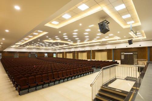 an empty auditorium with rows of chairs and a lectern at Premier Greens in Mūlki