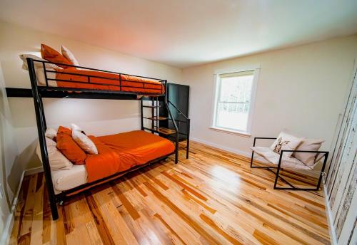 a bedroom with two bunk beds and a chair at Newly Built Retreat in the Woods Near Acadia in Trenton