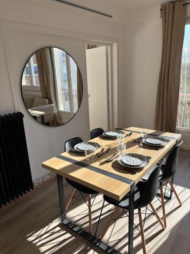 - une table à manger avec des chaises et un miroir dans l'établissement New, bright apartment, à Laval