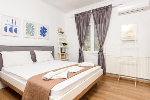 a white bedroom with a large bed and a window at Adamou Family House in Prinos