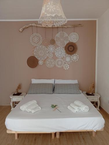 Un dormitorio con una cama blanca con toallas. en Kasa di Yo, en Maruggio