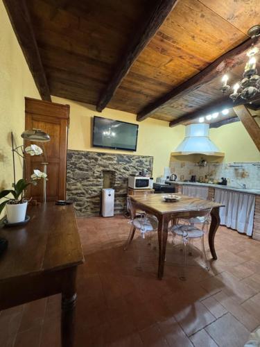 a kitchen with a wooden table and a stove at Casa Le Scese Porta di Valtellina in Piantedo