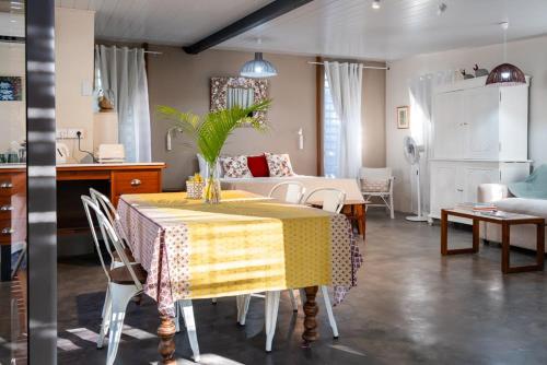 a dining room with a table and a living room at Le Jardin d'Antoinette in Rivière Noire