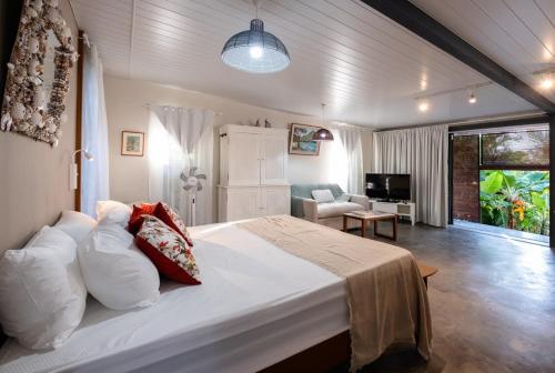 a bedroom with a large bed and a living room at Le Jardin d'Antoinette in Rivière Noire