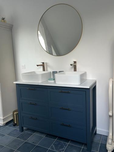 a bathroom with two sinks and a mirror at Havre de paix in Vimoutiers