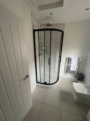 a bathroom with a glass shower and a sink at A Beautiful Four Bedroom Home Located in the Heart of Treherbert in Treorky