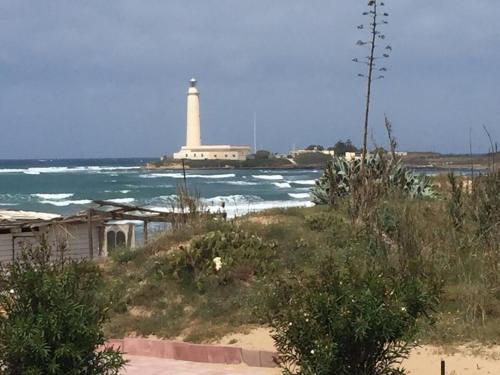 a lighthouse on the beach with the ocean at Beautiful sea front beach in Granitola