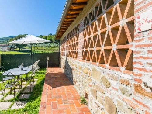 a brick building with a table and an umbrella at FATTORIA L'OTTAVO l'8 LARGE WINE AND OIL PRODUCERS in Lucolena in Chianti