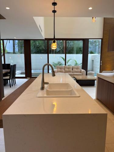 a kitchen with a sink and a living room at Luxury Exclusive Villa in Playa del Carmen