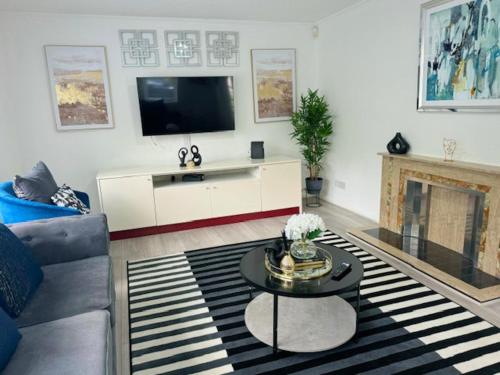 a living room with a couch and a tv at Bungalow - Sleeps 6 - Garden - Wheelchair Access in Leicester