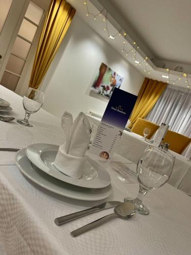 a white plate with a napkin on a table at Bassiana Hotel és Étterem in Sárvár