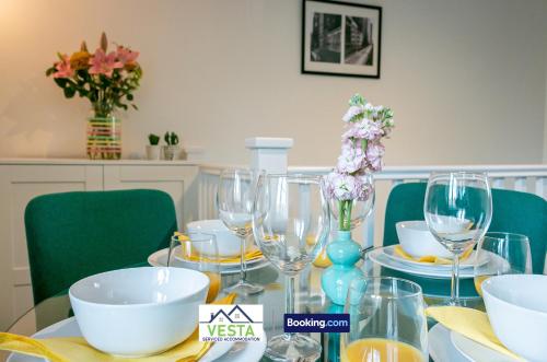 a dining room table with wine glasses and flowers on it at Three Bedroom Apartment By Vesta Serviced Accommodation & Short Lets Hatfield With Free Parking in Hatfield