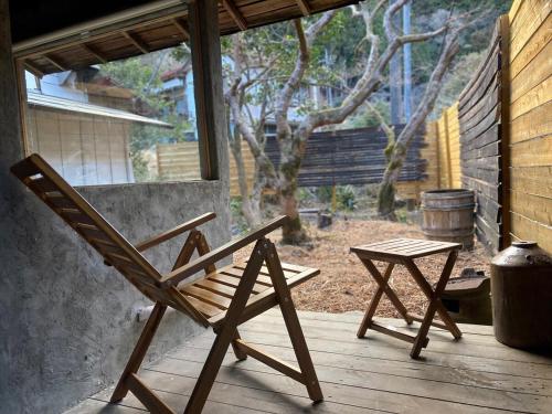 a wooden chair and a table on a porch at 紡舎 - BO-SHA - - 古民家一棟貸しVilla in Akiruno