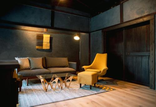 a living room with a couch and a table and chairs at 紡舎 - BO-SHA - - 古民家一棟貸しVilla in Akiruno