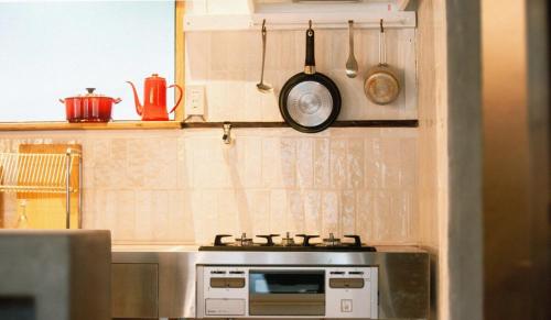 a kitchen with a stove and some pots and pans at 紡舎 - BO-SHA - - 古民家一棟貸しVilla in Akiruno