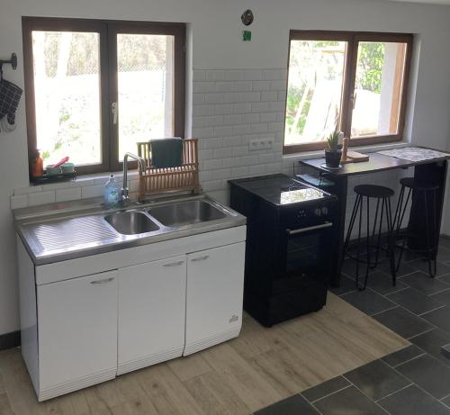 une cuisine avec un évier et un plan de travail dans l'établissement Cottage normand de 1930, à Manneville-sur-Risle