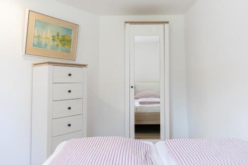 a bedroom with a bed and a dresser and a mirror at Bungalows Ostseequelle in Hohenkirchen