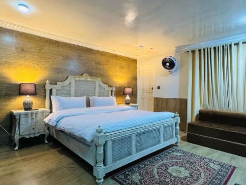 a bedroom with a large bed and a staircase at The Hermitage Cottage-Exclusive Mountain Escape in Murree
