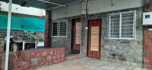 a building with two red doors and a window at Leela villa - Ancient Redstone Escape in Panchgani