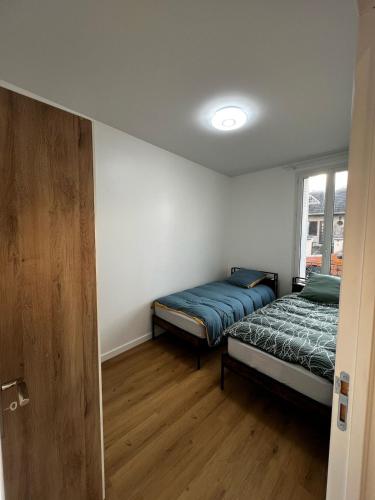 une chambre avec deux lits et une fenêtre dans l'établissement 2-room apartment Argenteuil, à Argenteuil