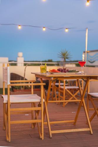 a wooden table and chairs on a deck at Hotel Sa Volta in Es Pujols