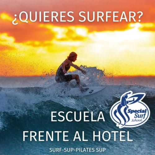a man riding a wave on a surfboard in the ocean at Hotel Milagros Golf in Mogro