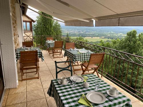 a patio with tables and chairs on a balcony at Manoir de Rieuzal in Loubressac