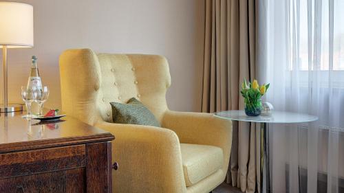a living room with a chair and a table at Hotel Central in Hof