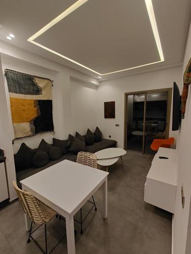 a living room with a couch and a table at Cocon moderne in Essaouira
