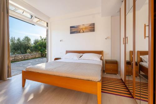 a bedroom with a bed and a large window at Villa Azzurro with Private Beach in Neum