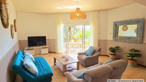 a living room with two couches and a tv at LAKAZ DEL SOL - Modern and elegant apartments with luxurious garden, pool and barbecue area - Tourism Permit Certified in Tamarin