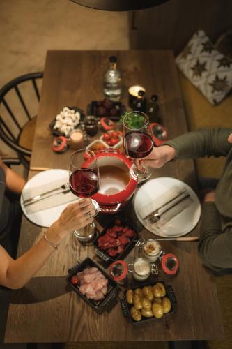 a table with two people holding glasses of wine at Agrad Chalets in Aschau im Chiemgau