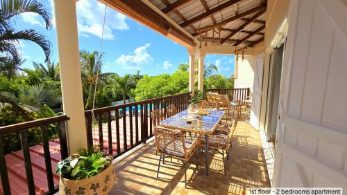 a patio with tables and chairs on a balcony at LAKAZ DEL SOL - Modern and elegant apartments with luxurious garden, pool and barbecue area - Tourism Permit Certified in Tamarin