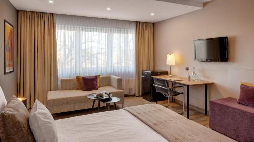 a hotel room with a bed and a desk at Hotel Central in Hof